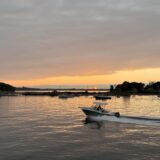 Boat cruising Casco Bay during a golden hour sunset near Portland, Maine